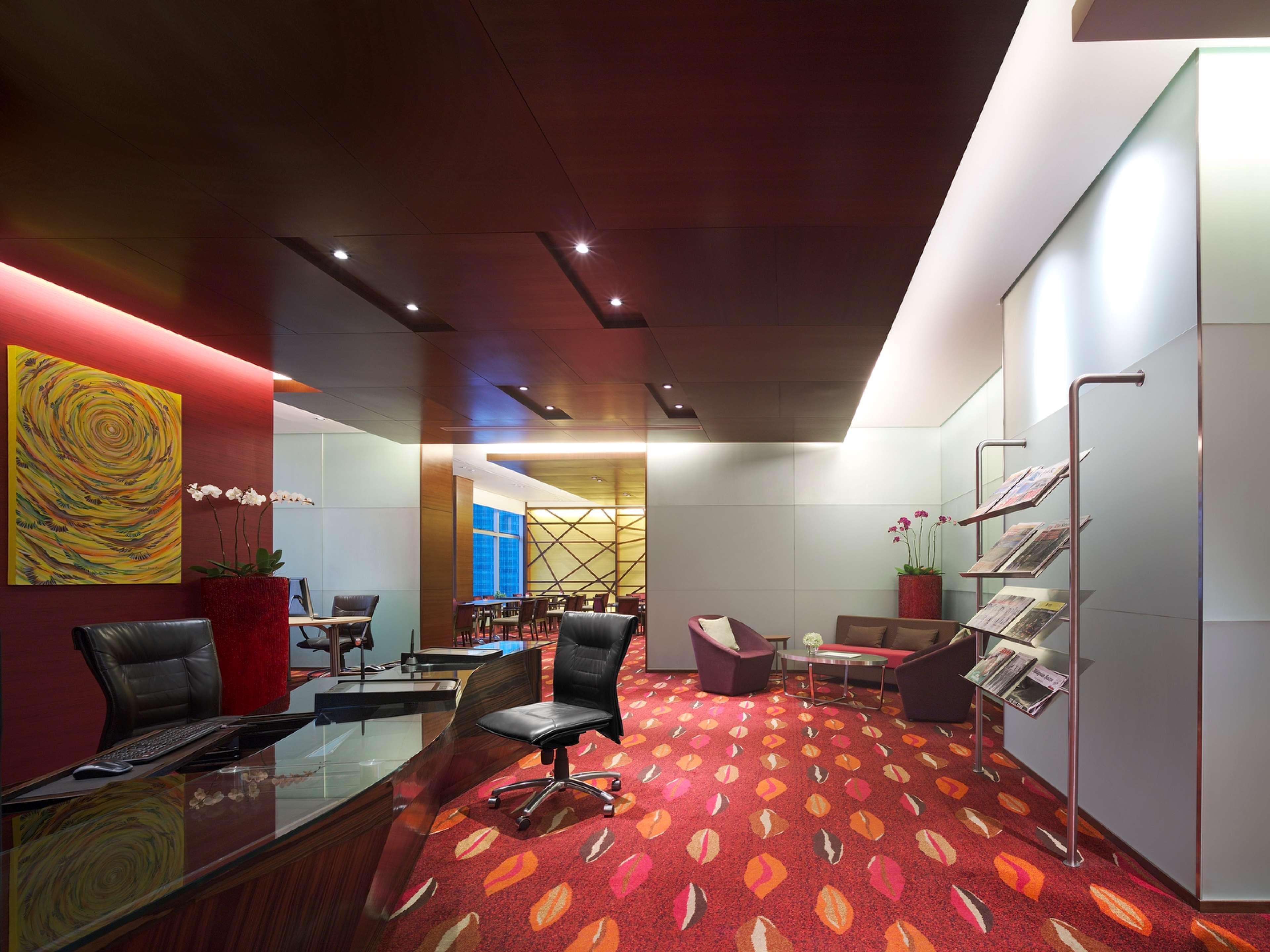 Traders Hotel, Κουάλα Λουμπούρ Εξωτερικό φωτογραφία The photo depicts a modern lobby or reception area. It features elegant wooden paneling and soft lighting, creating a warm and inviting atmosphere. The floor has a patterned carpet with vibrant colors, adding a contemporary touch. 

In the foreground