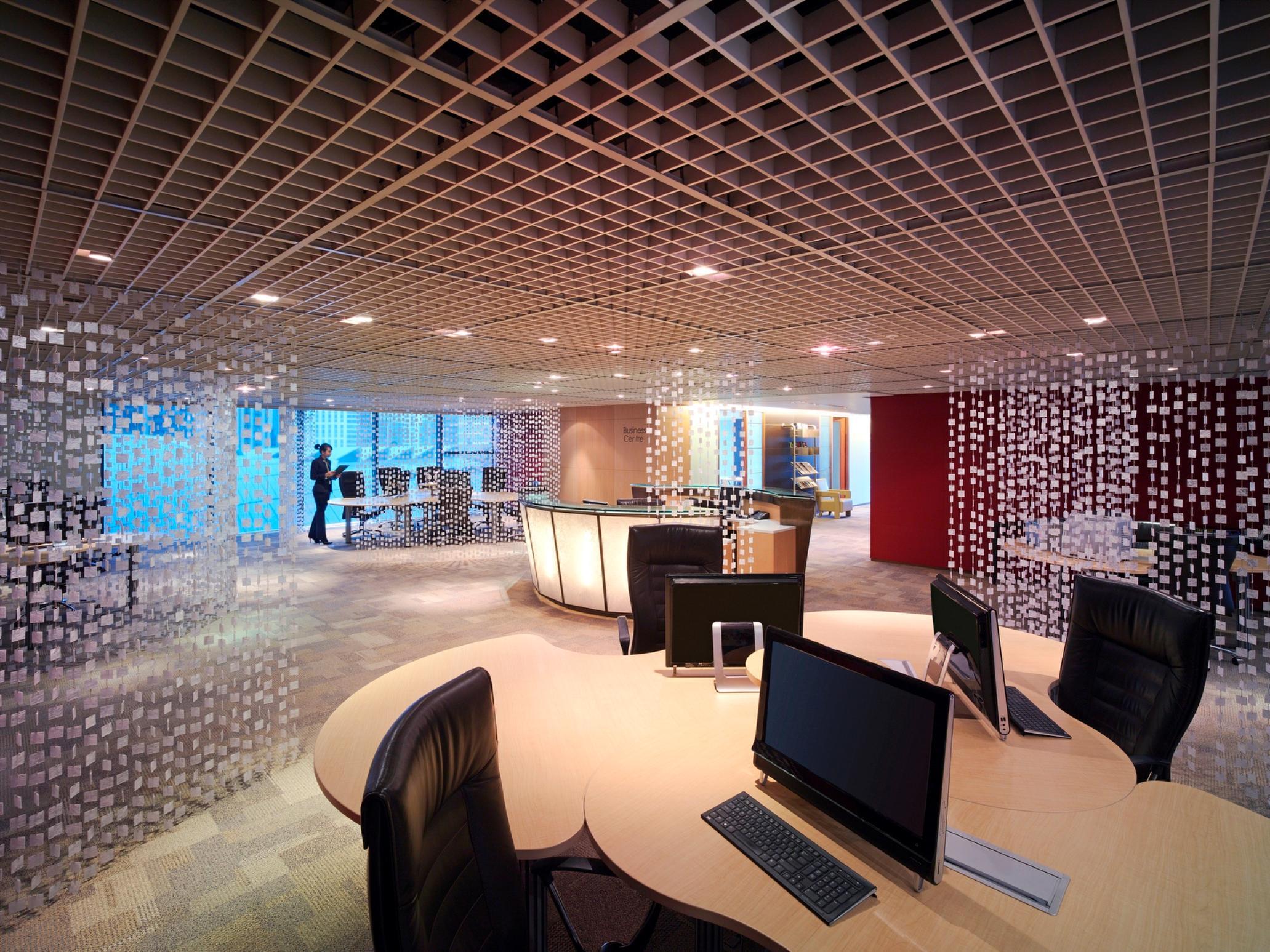 Traders Hotel, Κουάλα Λουμπούρ Εξωτερικό φωτογραφία The photo shows a modern office interior. It features a spacious layout with several workstations equipped with computers and ergonomic chairs. The design includes a unique ceiling with a grid pattern that gives a contemporary feel. There are transpa